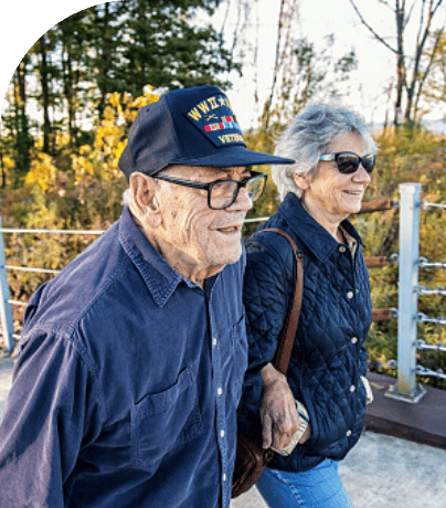 two elderly man and woman walking