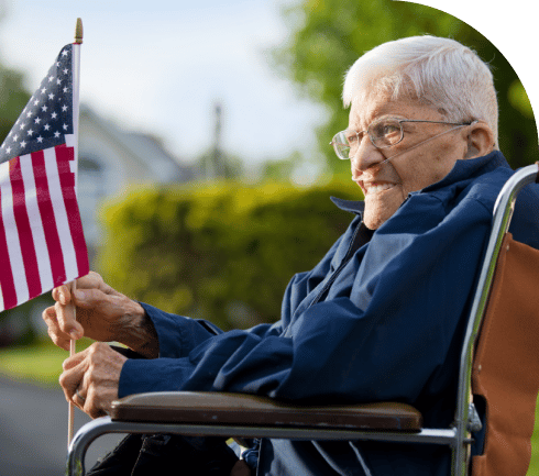 an older veteran holding an American flag