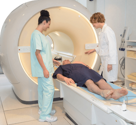 A doctor and a nurse watching a patient go into the MRI