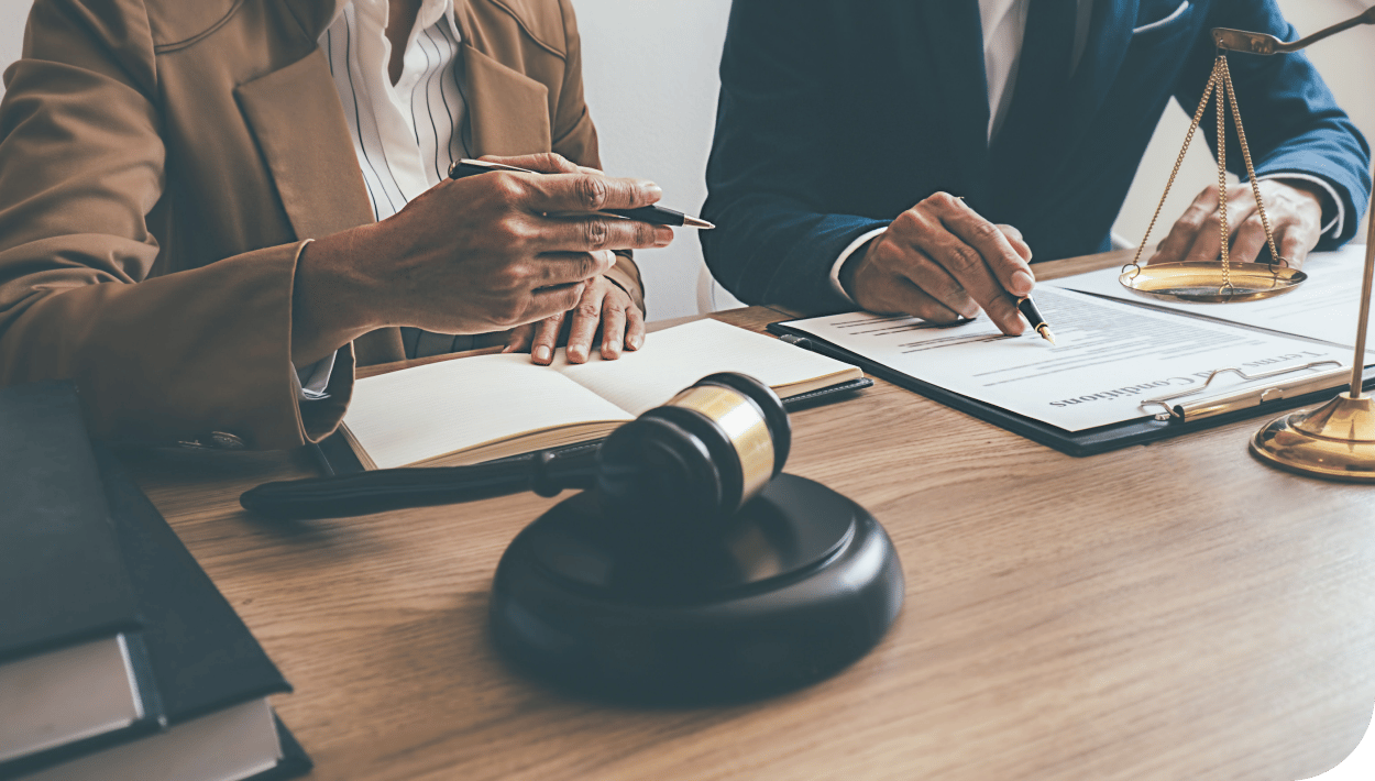 two sets of hands over paperwork - lawyer showing client where to sign