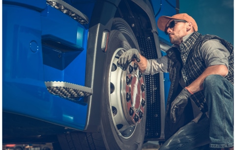 man examining truck tires