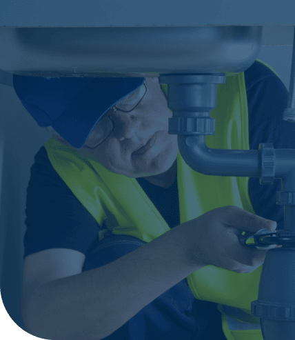 Plumber working under sink