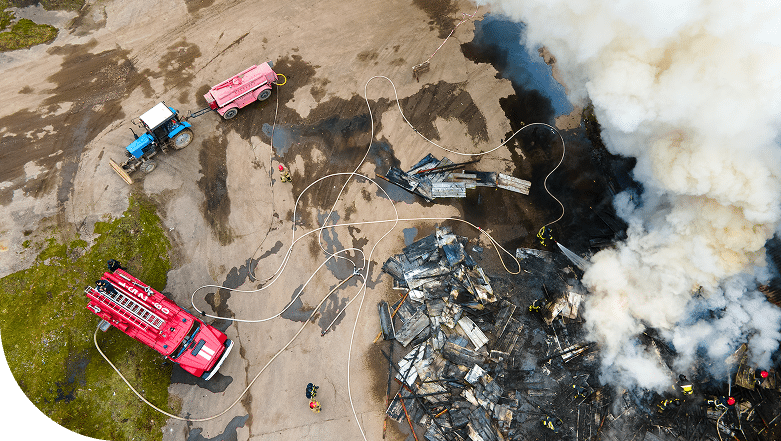 Aerial view of an industrial accident site with firefighters trucks