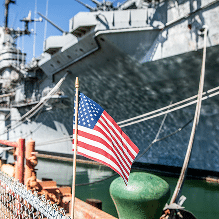 Navy ship in port with a US flag