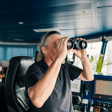 Person with binoculars in a boat