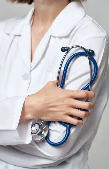 Female mesothelioma doctor wearing a white robe and holding a blue stethoscope