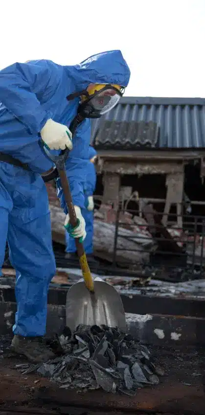 Asbestos abatement specialist wearing a protective suit, removing asbestos in an Illinois exposure site