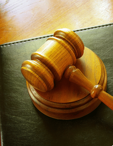 Light wooden gavel on top of a green book