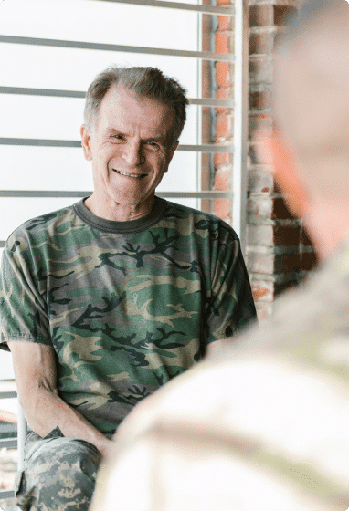 Senior U.S. veteran talking to a person and sitting on a chair