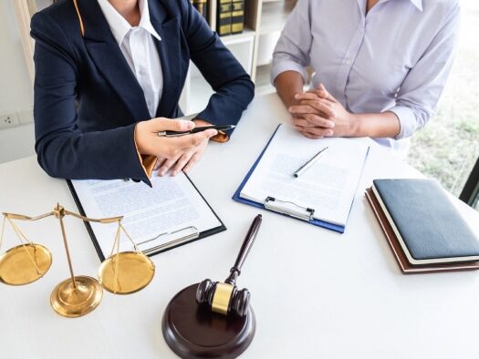 Mesothelioma lawyer explaining the statute of limitations for filing a claim to a client with a view of the attorney's desk