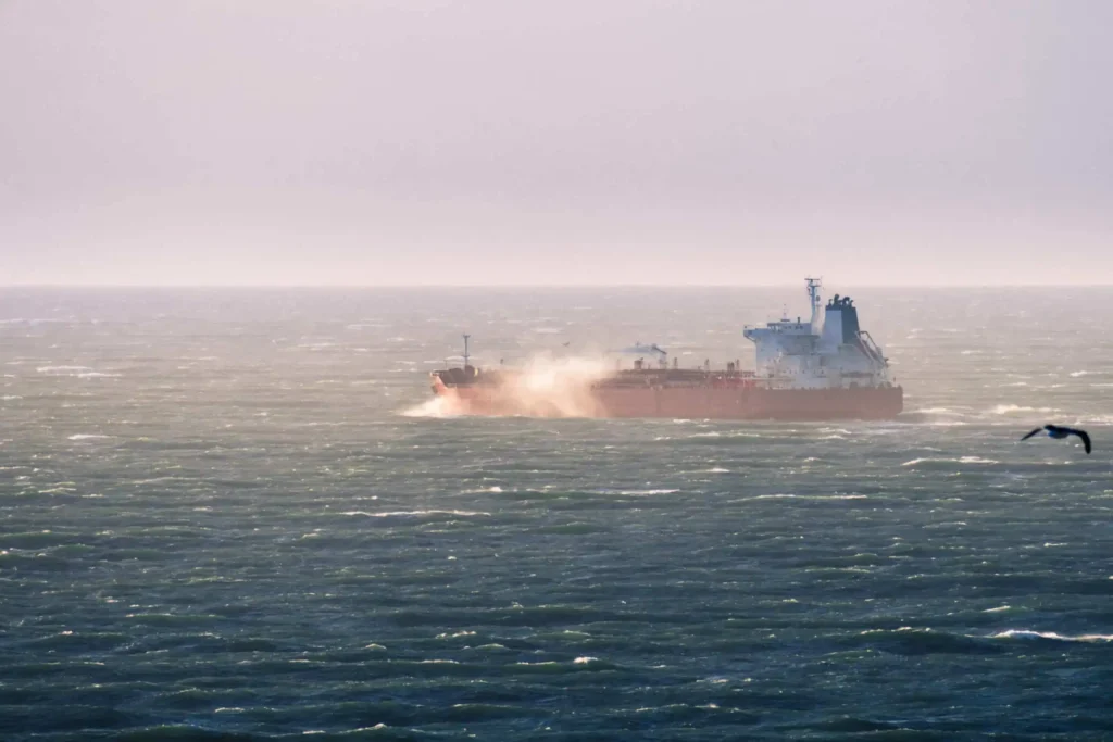 Cargo ship leaving a bay area and under the Jones Act while close to shore