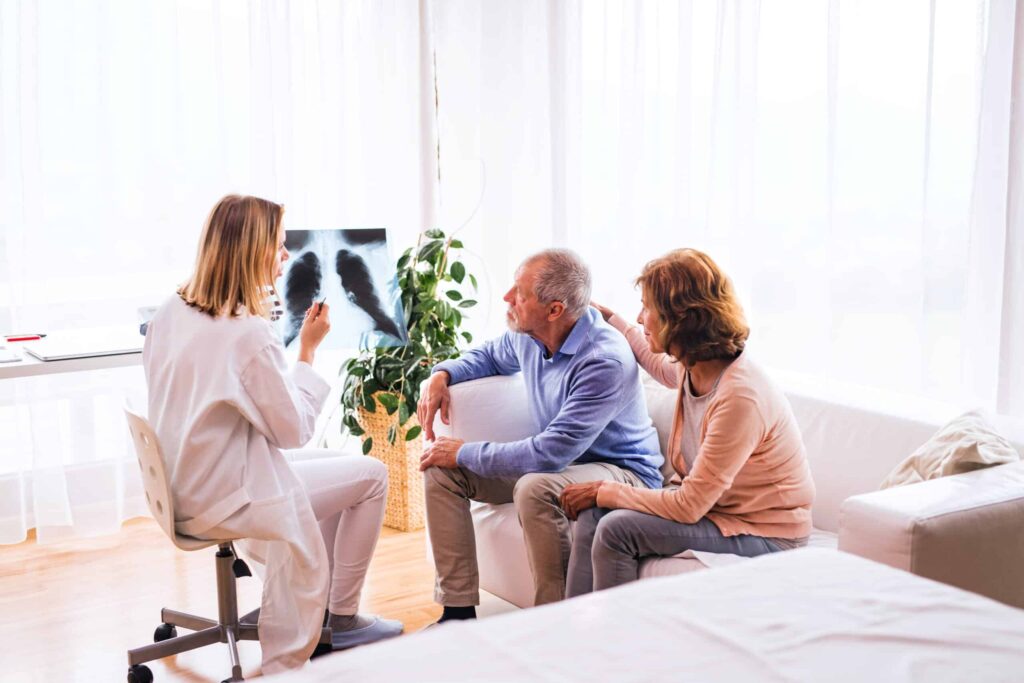 Female doctor showing a senior couple with mesothelioma their x-rays