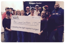 People in the Houston Food Bank holding a large check by the Lanier Law Firm