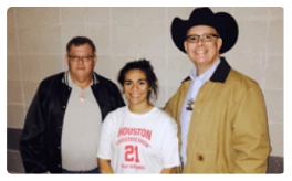 A Lanier Law Firm employee in the Houston Livestock Show and Rodeo with two other people