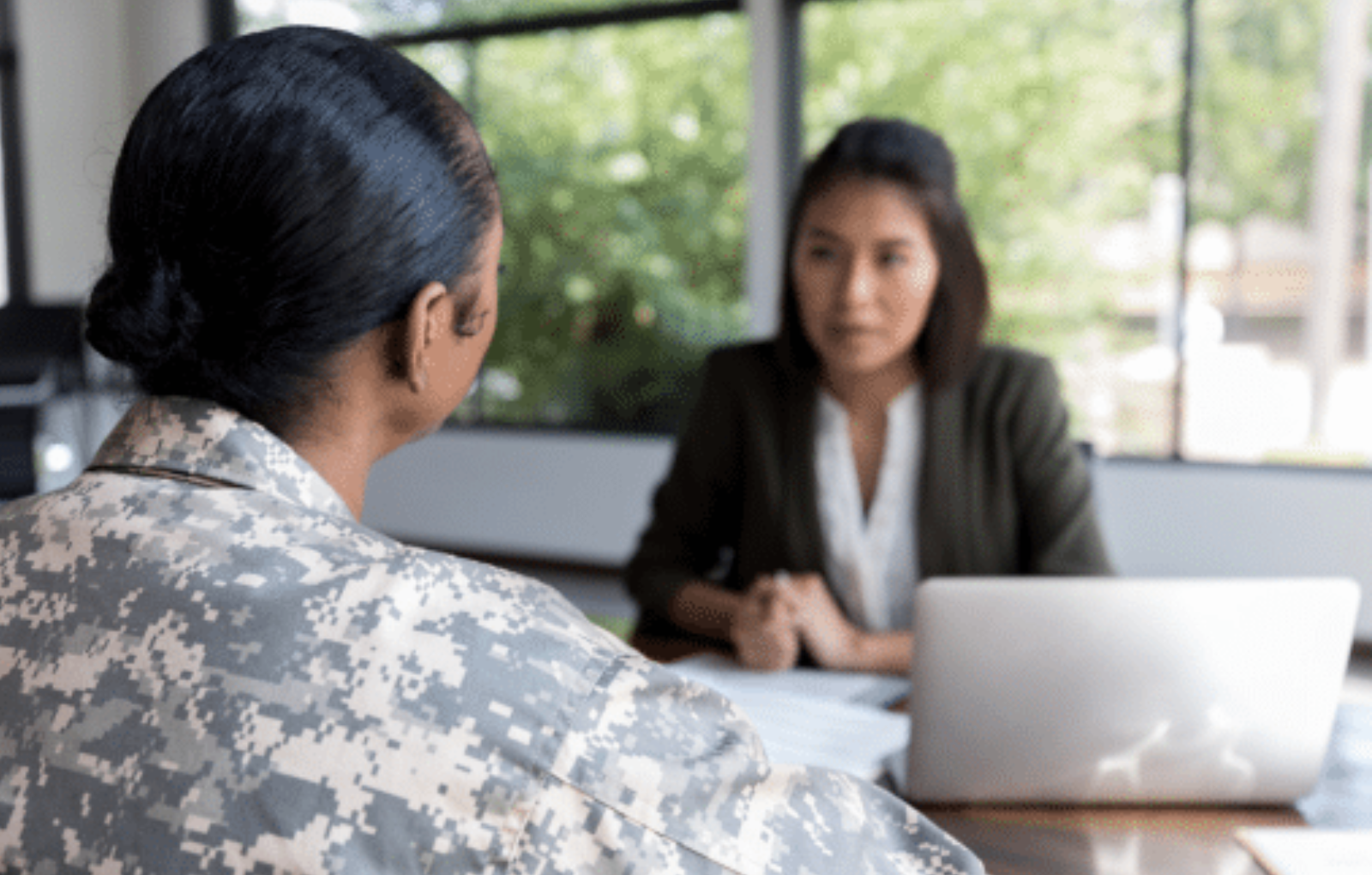 Veteran woman with mesothelioma sitting across from attorney at table