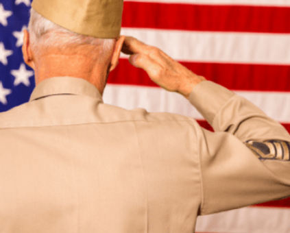 Veteran who received mesothelioma benefits saluting at the flag