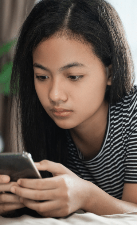 Young girl holding her phone looking at Facebook and Instagram