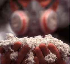 Worker with protective equipment holding asbestos fibers