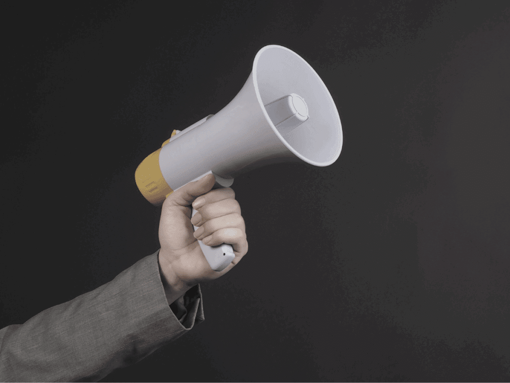 An arm in a suit holding a megaphone