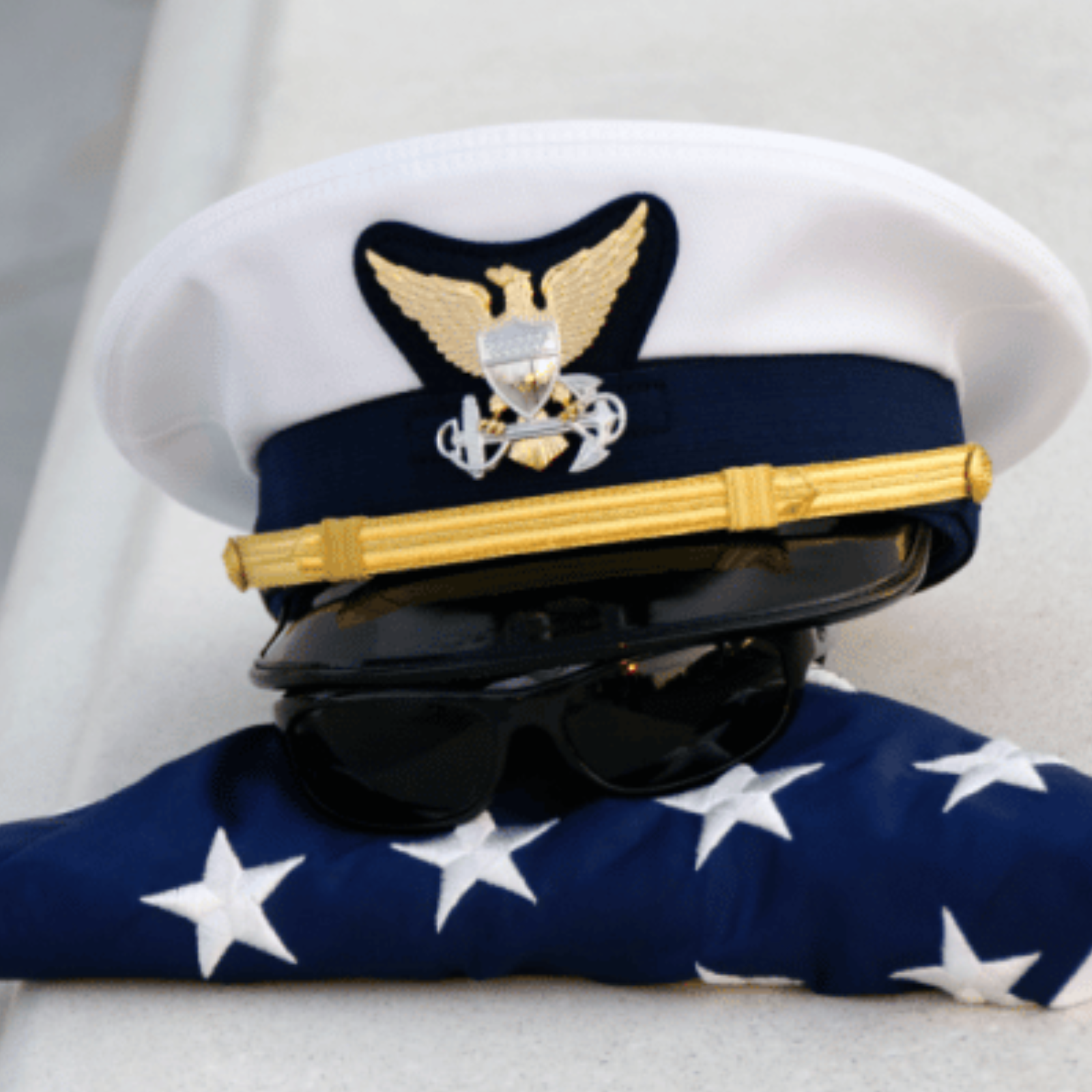 A coast guard hat on top of an American flag