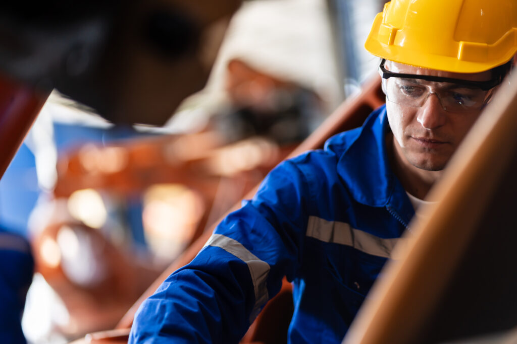 Engineer worker with mesothelioma wearing a yellow helmet and pausing during work contemplating worker's comp options