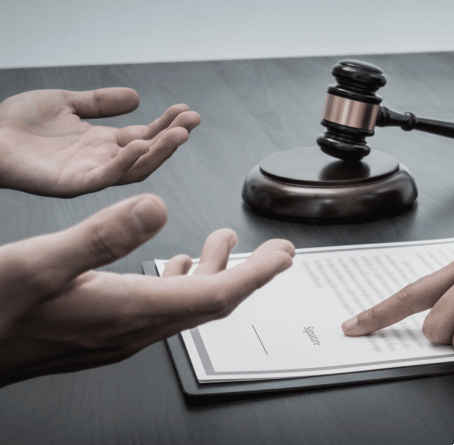 Hands asking why, and a finger pointing to words on a paper with a gavel in the background