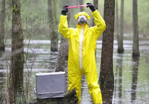 Men wearing protective equipment testing water contamination