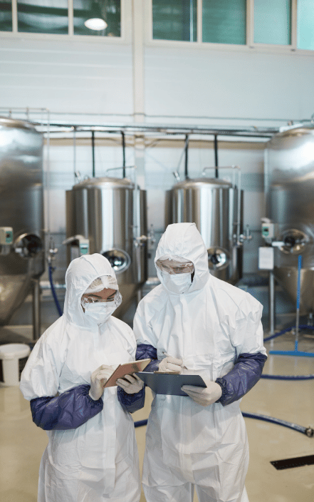 Two chemical plant workers wearing protective equipment