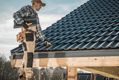 Roofer On Ladder Inspecting Shingles