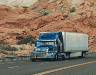 Blue truck with a desert landscape in the background