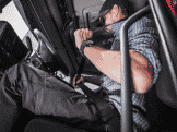 Truck driver fastening seat belt before driving