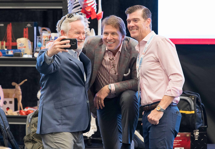 Mark Lanier taking a photo with 2 Lanier Trial Academy attendees