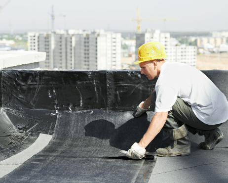 Construction Worker on Roof Handling Asbestos Felt