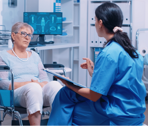 Woman sitting on a wheelchair listening to a doctor