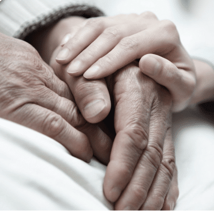 A young hand over two belonging to an elderly person