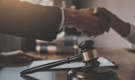 Attorney shaking hands with client and a gavel