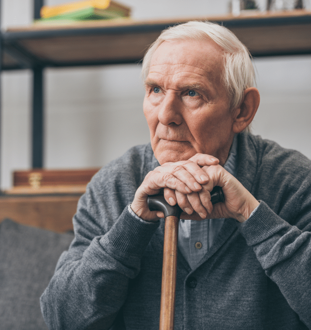 Senior resting chin on a cane