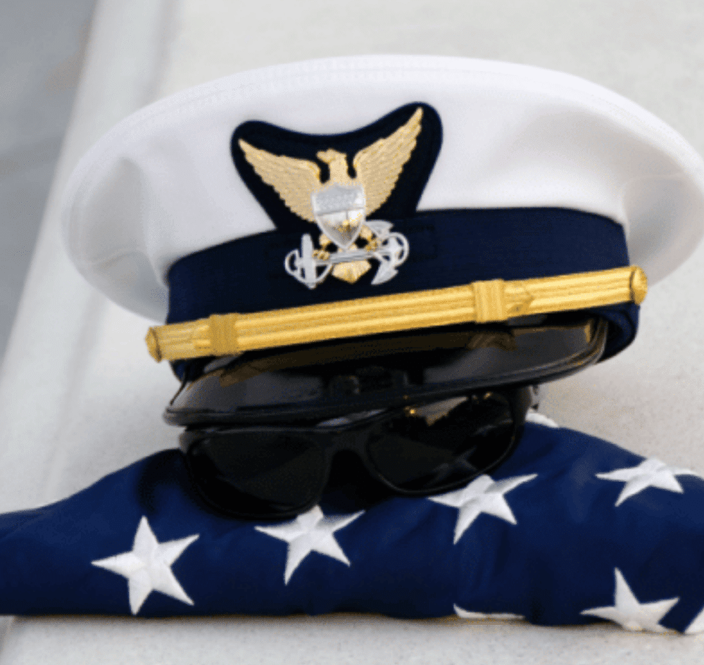 A coast guard hat on top of an American flag