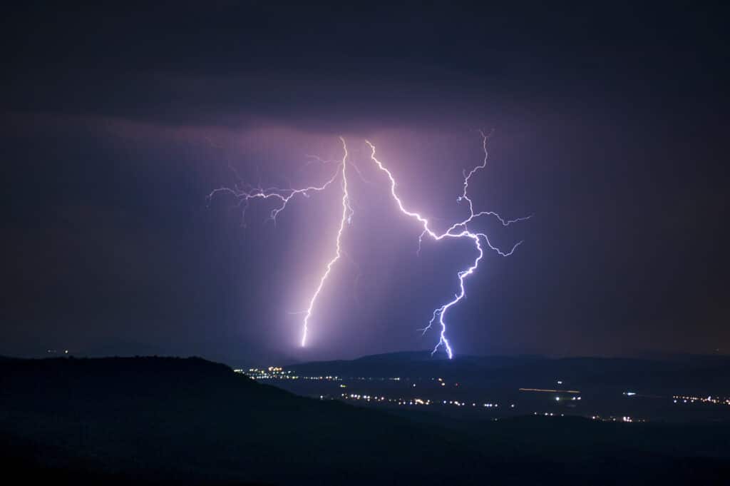 Lightning storm over a city at night